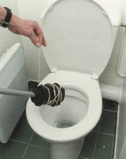 Objeto caseiro improvisado com cabo e panos amarrados tentando desentupir vaso sanitário.